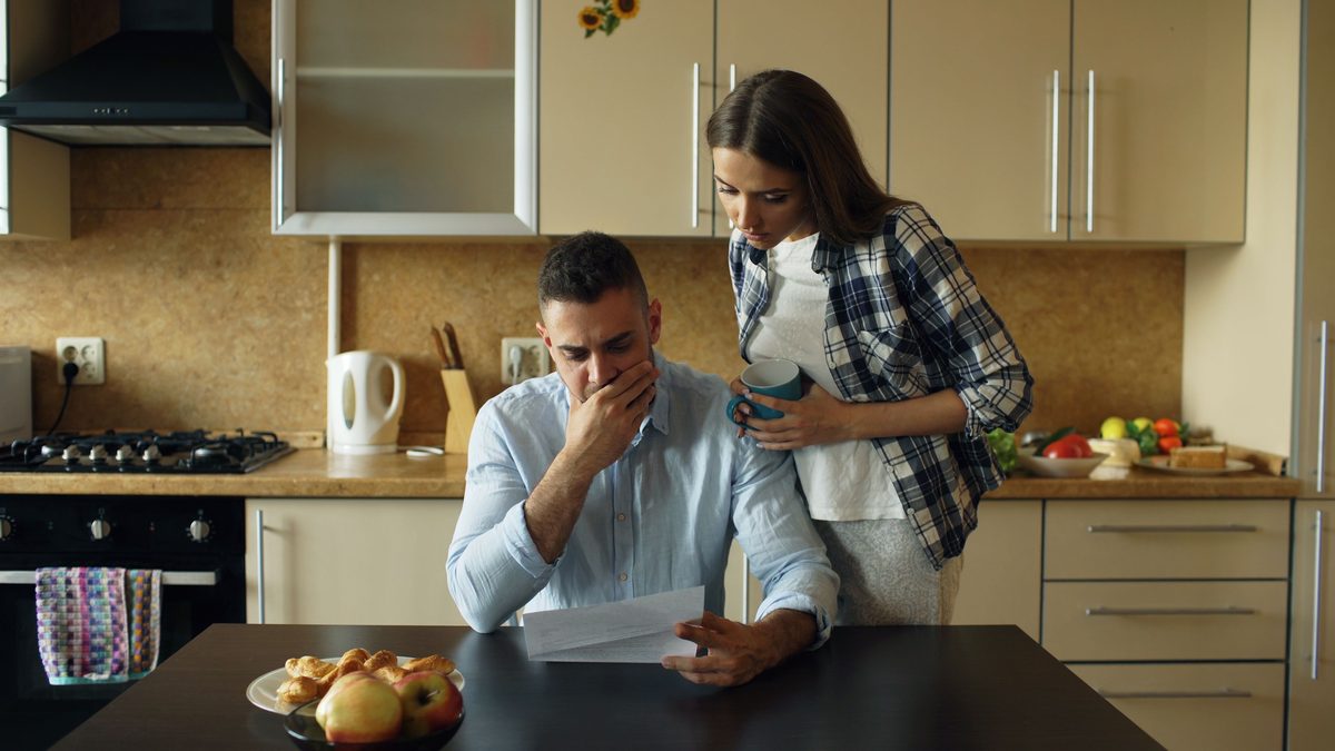 גבר ואישה במטבח קוראים יחד מכתב
